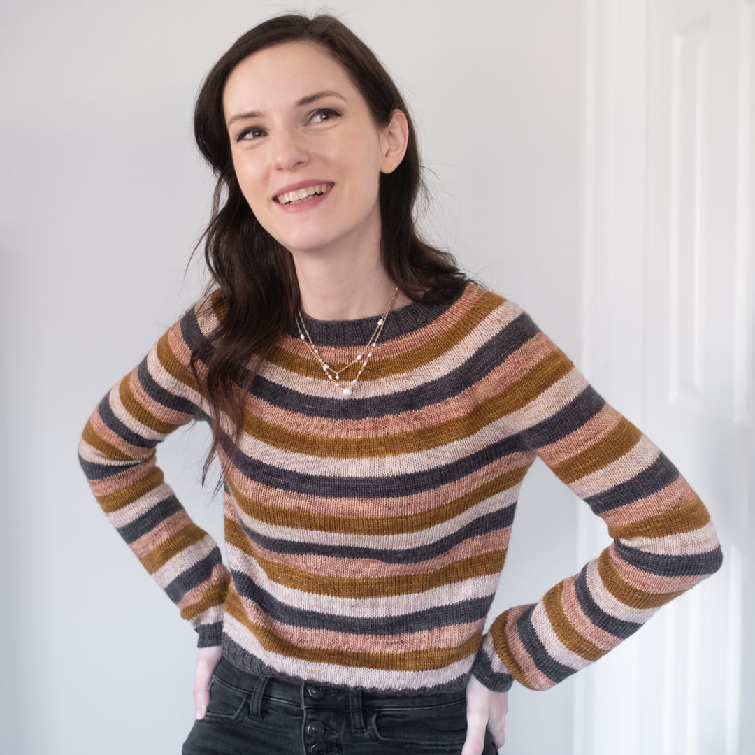 Kristin Lehrer's Profile Photo. She is shown smiling, arms akimbo while wearing her hand knit Stripes Pullover — a knitting pattern by Andrea Mowry